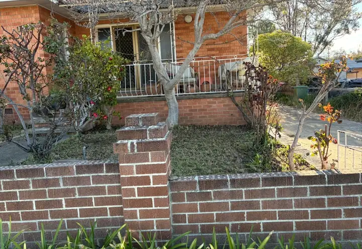 After: front garden cut back and tidy behind a brick fence